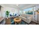 Bright living room featuring a comfortable sofa, stylish decor, and large windows with scenic views with a ceiling fan at 650 70Th Ave, St Pete Beach, FL 33706