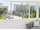 Bright living space featuring a large window with a neighborhood view, showcasing nearby buildings and lush palm trees at 650 70Th Ave, St Pete Beach, FL 33706