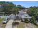 Aerial view of home featuring large driveway, mature trees, and attached garage at 7004 Lambright Ct, Tampa, FL 33634