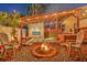 Relaxing backyard space with a fire pit, fireplace, and hot tub under string lights at 7010 N Hubert Ave, Tampa, FL 33614