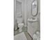 This bathroom has a toilet, sink and oval mirror along with a window with a new set of blinds at 7010 N Hubert Ave, Tampa, FL 33614