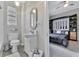 This bathroom features a new toilet and sink along with an oval mirror and decorative basket at 7010 N Hubert Ave, Tampa, FL 33614