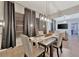 Modern dining room with a contemporary chandelier and gray curtains at 7010 N Hubert Ave, Tampa, FL 33614