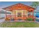 Inviting front porch with craftsman style wood beams and trim, and decorative landscaping at 7010 N Hubert Ave, Tampa, FL 33614