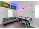 Inviting game room features an air hockey table and comfortable couch beneath neon signage and ambient lighting at 7010 N Hubert Ave, Tampa, FL 33614