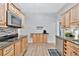 Kitchen featuring stainless steel appliances, wood cabinets, and a coffee station at 7010 N Hubert Ave, Tampa, FL 33614