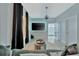 Contemporary living room featuring gray walls, decorative lighting, and open layout to bedroom at 7010 N Hubert Ave, Tampa, FL 33614