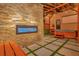 Outdoor patio with stone fireplace, hot tub, outdoor projector screen, and paver flooring at 7010 N Hubert Ave, Tampa, FL 33614