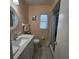 Neutral bathroom features a tiled floor, white fixtures, and framed mirror at 7303 9Th W Ave # 7303, Bradenton, FL 34209