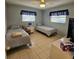 Guest bedroom includes tiled floors, two twin beds, and a ceiling fan at 7303 9Th W Ave # 7303, Bradenton, FL 34209