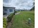 View of the condo's patio with an air conditioner and view of green lawns around the building at 7303 9Th W Ave # 7303, Bradenton, FL 34209