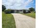 Charming single-story home with a well-manicured lawn and a concrete driveway leading to an attached garage at 7303 9Th W Ave # 7303, Bradenton, FL 34209