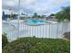View of the community swimming pool surrounded by a white fence and lounge chairs at 7303 9Th W Ave # 7303, Bradenton, FL 34209