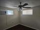Well lit room features wood floors, two windows, and a ceiling fan at 7307 50Th N Ave, St Petersburg, FL 33709