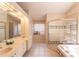 This bathroom features double sinks, a large mirror, a step-in shower and a bathtub at 7838 Trail Run Loop, New Port Richey, FL 34653
