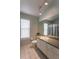 Clean bathroom with a large mirror, white vanity, and a window for natural light, exuding simplicity at 7838 Trail Run Loop, New Port Richey, FL 34653