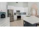 Bright kitchen featuring white cabinetry, stainless appliances, and a beautiful blue tile backsplash at 7838 Trail Run Loop, New Port Richey, FL 34653