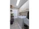 Functional laundry room with white appliances, ample storage, and natural light from the window at 7838 Trail Run Loop, New Port Richey, FL 34653