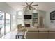 Open living room with a fireplace, large windows, and a view of the backyard pool at 7838 Trail Run Loop, New Port Richey, FL 34653