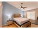 Spacious primary bedroom with wood accent headboard, hardwood floors, ceiling fan, and natural light at 7838 Trail Run Loop, New Port Richey, FL 34653