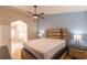This main bedroom features a ceiling fan, wood flooring, and an attached bathroom with a step-in shower at 7838 Trail Run Loop, New Port Richey, FL 34653