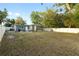 Expansive fenced backyard with a patio and mature trees offering plenty of space for outdoor activities and entertaining at 8001 N Ola Ave, Tampa, FL 33604