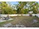 Spacious backyard showcasing a dining set on a patio, a storage shed, and a well-maintained fence for privacy at 8001 N Ola Ave, Tampa, FL 33604