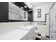 Retro bathroom featuring black and white checkered tile, ample vanity space and a marble-esque shower curtain at 8001 N Ola Ave, Tampa, FL 33604