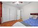 Cozy bedroom with wood floors, a ceiling fan, built-in shelving, and ample closet space at 8001 N Ola Ave, Tampa, FL 33604