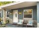 Inviting front porch features decorative stone accents, comfortable seating, and a stylish front door with glass detailing at 8001 N Ola Ave, Tampa, FL 33604