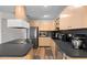 Bright kitchen with wood cabinets, stainless steel fridge, black countertops and backsplash, complemented by wood-look floors at 8001 N Ola Ave, Tampa, FL 33604