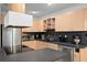 Well-lit kitchen with wooden cabinets, stainless steel appliances, and gray countertops for a modern feel at 8001 N Ola Ave, Tampa, FL 33604