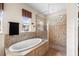 Bathroom featuring a large soaking tub, tiled shower, and picture window at 8308 Mobile Cir, Weeki Wachee, FL 34613