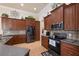 Well-equipped kitchen featuring dark wood cabinetry, stainless steel appliances, and tiled backsplash at 8308 Mobile Cir, Weeki Wachee, FL 34613