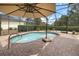 Inviting screened-in pool area with brick pavers and sunshade for ultimate relaxation and backyard privacy at 8308 Mobile Cir, Weeki Wachee, FL 34613