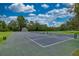 A well-maintained tennis court with lush green surroundings and sunny skies at 8308 Mobile Cir, Weeki Wachee, FL 34613