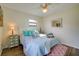 Cozy bedroom features light walls, ceiling fan, charming decorations, and plank flooring at 8722 Thornwood Ln, Tampa, FL 33615