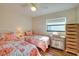 Charming bedroom showcases twin beds, ceiling fan, plank flooring and natural light at 8722 Thornwood Ln, Tampa, FL 33615