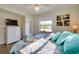 This bedroom offers a light ceiling fan, plank floors, bright window and tropical artwork at 8722 Thornwood Ln, Tampa, FL 33615