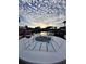 Outdoor seating area with a fire pit and beautiful waterfront views at sunset at 8722 Thornwood Ln, Tampa, FL 33615