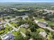 Overhead view of a residential home in a suburban neighborhood setting featuring many mature trees and green lawns at 903 Tomahawk Trl, Brandon, FL 33511