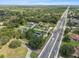 A high aerial view of a residential home near a highway with plenty of mature trees and greenery at 903 Tomahawk Trl, Brandon, FL 33511