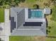 An overhead perspective of a house with solar panels and a screened-in pool, surrounded by lush landscaping at 903 Tomahawk Trl, Brandon, FL 33511