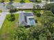 Aerial view of the home with a screen-enclosed pool in a neighborhood with green lawns and mature trees at 903 Tomahawk Trl, Brandon, FL 33511