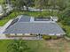 Aerial view of ranch-style home with pool, well-maintained landscaping, and a gray shingle roof at 903 Tomahawk Trl, Brandon, FL 33511