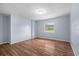 Bedroom featuring light-blue walls, wood flooring, and a window overlooking the lawn at 903 Tomahawk Trl, Brandon, FL 33511