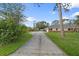 Long driveway leading to a well-maintained home with a lush lawn and mature trees at 903 Tomahawk Trl, Brandon, FL 33511