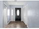 Inviting entryway showcasing neutral tiling, a black door, and closet at 903 Tomahawk Trl, Brandon, FL 33511
