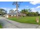 View of the house and long driveway with well-kept lawn and mature trees on a sunny day at 903 Tomahawk Trl, Brandon, FL 33511
