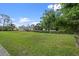 Expansive green front lawn of a home nestled among mature trees and lush landscaping at 903 Tomahawk Trl, Brandon, FL 33511